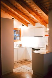 - une cuisine avec des placards blancs et un évier dans l'établissement Chalet le Joyau, à Nendaz