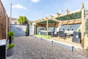 a backyard with a pergola and a table and chairs at Stunning house close to the stadium + Hot tub! in Liverpool