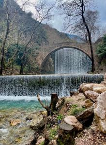 a bridge over a waterfall next to a river at Guesthouse Alexandros in Pýli +13 photos