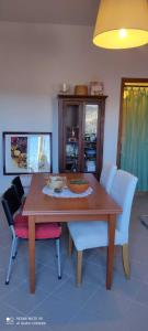 una mesa de comedor con sillas blancas alrededor en Casa nella Natura en Caramanico Terme