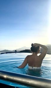 une femme assise dans une piscine à l'eau dans l'établissement Studio Geek Villa - Open Space - all year round Pool, Dining Pergola, Barbecue - Funchal Holiday Home by Salviati Stays, à Funchal