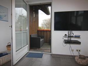 un porche con una gran TV en la pared en Holiday complex Wenkendorf, Fehmarn-Wenkendorf, en Lemkendorf