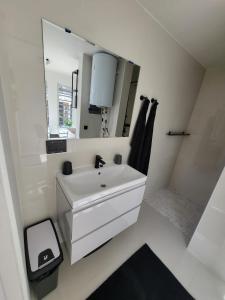 a white bathroom with a sink and a mirror at Appartement S2 in Jan Thiel