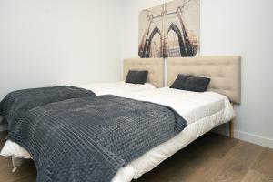 a bedroom with a bed with white sheets and a picture on the wall at URBANIZACION CON PISCINA ARNELAS SANXENXO in Sanxenxo +24 photos