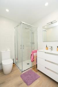 a bathroom with a shower and a toilet and a sink at URBANIZACION CON PISCINA ARNELAS SANXENXO in Sanxenxo