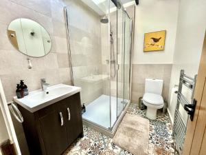 W łazience znajduje się prysznic, umywalka i toaleta. w obiekcie Attenborough Cottage - 2 Bedroom Cottage w mieście Tredegar