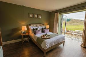 a bedroom with a bed and a sliding glass door at The Grange in Upper Arley