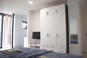 a bedroom with a bed and a large white cabinet at City center apartment in Koper