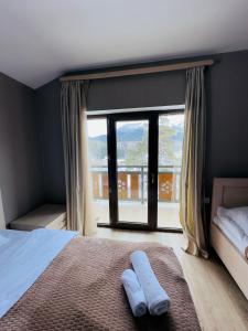 ein Schlafzimmer mit einem Bett und einem großen Fenster in der Unterkunft Villa B Barleon-Bakuriani in Bakuriani