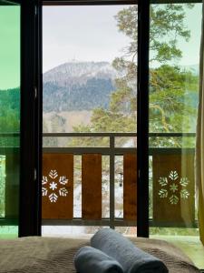 a bedroom with a view of a mountain through a window at Villa B Barleon-Bakuriani in Bakuriani