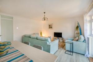 a living room with blue couches and a tv at 44 West Front Road in Bognor Regis