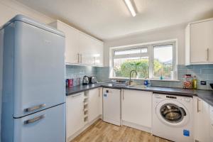 a kitchen with a refrigerator and a washing machine at 44 West Front Road in Bognor Regis