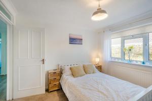 a white bedroom with a bed and a window at 44 West Front Road in Bognor Regis