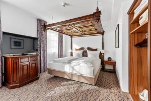 um quarto com uma cama de dossel e um armário de madeira em King's Hotel Center Superior em Munique