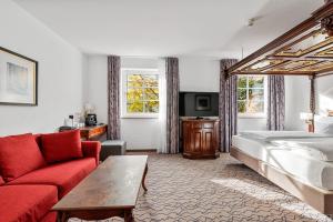 a hotel room with a bed and a red couch at King's Hotel Center Superior in Munich