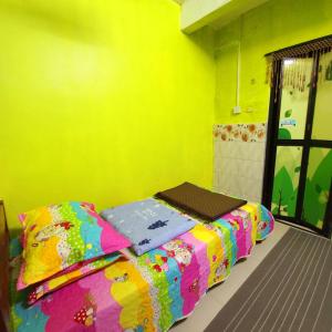 um quarto com uma cama num quarto amarelo em Nur's Homestay em Seri Manjung