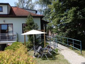 a group of chairs and an umbrella in front of a house at Pension Terezka in Frymburk