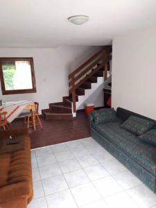 a living room with a couch and a staircase at Tassi Halászcsárda - Sügér ház in Tass