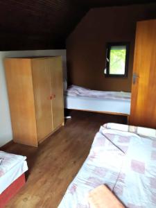 TassにあるTassi Halászcsárda - Sügér házのベッド2台とキャビネット付きの小さな部屋です。