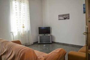sala de estar con TV y sofá en Trilocale a 300 metri dal mare Gambero en Alguer