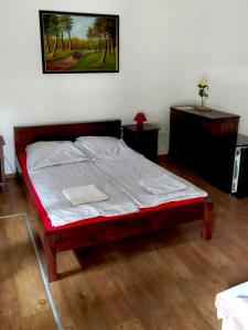 a bedroom with a bed and a picture on the wall at Tassi Halászcsárda - Sügér ház in Tass