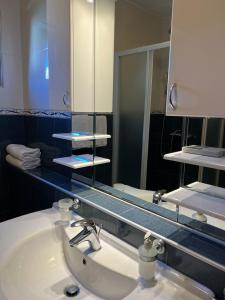 a bathroom with a sink and a large mirror at Apartments Radulovic in Kotor