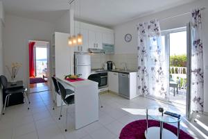 a white kitchen with a table and chairs in it at Sunset apartments in Hvar