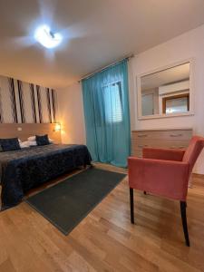 1 dormitorio con 1 cama y 1 silla en Apartments Radulovic en Kotor