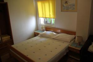 a small bedroom with a bed and a window at Apartments Juraj in Drasnice