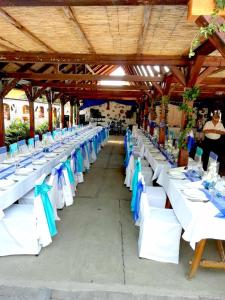 una fila de mesas con sillas azules y blancas en Tassi Halászcsárda - Sügér ház en Tass