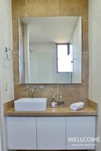 y baño con lavabo y espejo. en NUEVO! Hermoso y Exclusivo Apto para 4 en Zazué, en Santa Marta