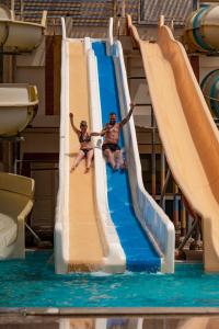 two men sliding down a water slide at a water park at King Tut Aqua Park Beach Resort in Hurghada