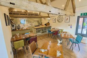 a restaurant with tables and chairs and a kitchen at The Grange in Upper Arley +29 photos