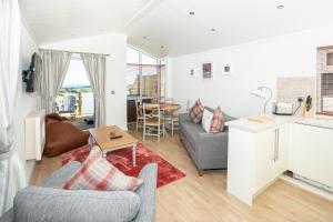 a living room with a couch and a table at Letham Feus Lodge and Caravan Park in Fife