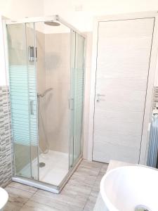 a bathroom with a glass shower and a tub at Savannah Charme Apartment in La Spezia