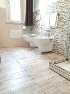a bathroom with two sinks and a toilet and a tub at Savannah Charme Apartment in La Spezia