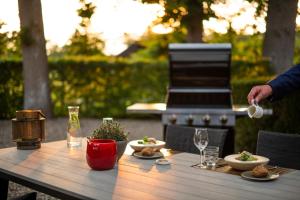 een houten tafel met borden met eten erop bij Koetshuis Landgoed Lauswolt in Beetsterzwaag