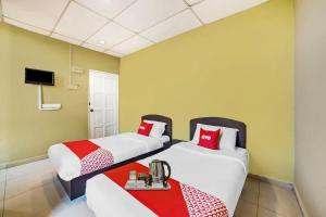 a hotel room with two beds and a table at Hotel Lii View in Mersing