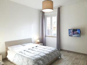 a white bedroom with a bed and a window at Savannah Charme Apartment in La Spezia