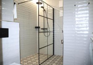 a shower with a glass door in a bathroom at Apartmenthaus Ahorn in Mittelberg