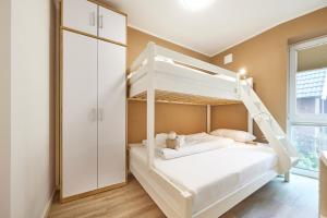 ein Schlafzimmer mit einem Etagenbett mit einer Leiter in der Unterkunft Nordseestern in Cuxhaven