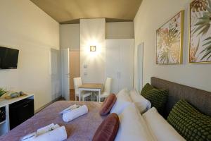 um quarto com uma cama com almofadas e um sofá em Verona Suites and Rooms em Verona
