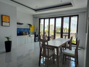 a kitchen and dining room with a table and chairs at Atap Biru Residence in Semarang