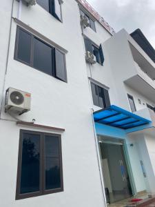 un edificio blanco con ventanas y toldo azul en Nhà Nghỉ Hương Trà Minh Đài 