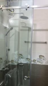 ducha con puerta de cristal y lavamanos en Nhà Nghỉ Hương Trà Minh Đài 