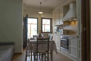 une cuisine avec une table et des chaises dans l'établissement Appartamento a 200 metri dal mare Granseola, à Alghero