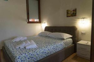 - une chambre avec un lit et des serviettes blanches dans l'établissement Appartamento a 200 metri dal mare Granseola, à Alghero