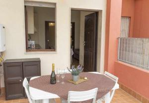 tavolo da pranzo con bottiglia di vino di Appartamento a 200 metri dal mare Granseola ad Alghero Altre 16 foto