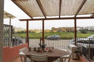 d'une terrasse avec une table et des chaises sur un balcon. dans l'établissement Appartamento a 200 metri dal mare Granseola, à Alghero