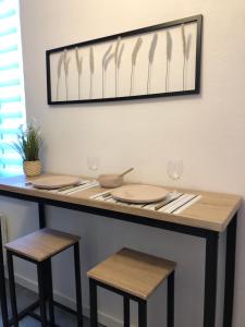- une table avec deux chaises, des assiettes et des verres à vin dans l'établissement Studio proche centre-ville 2, à Reims